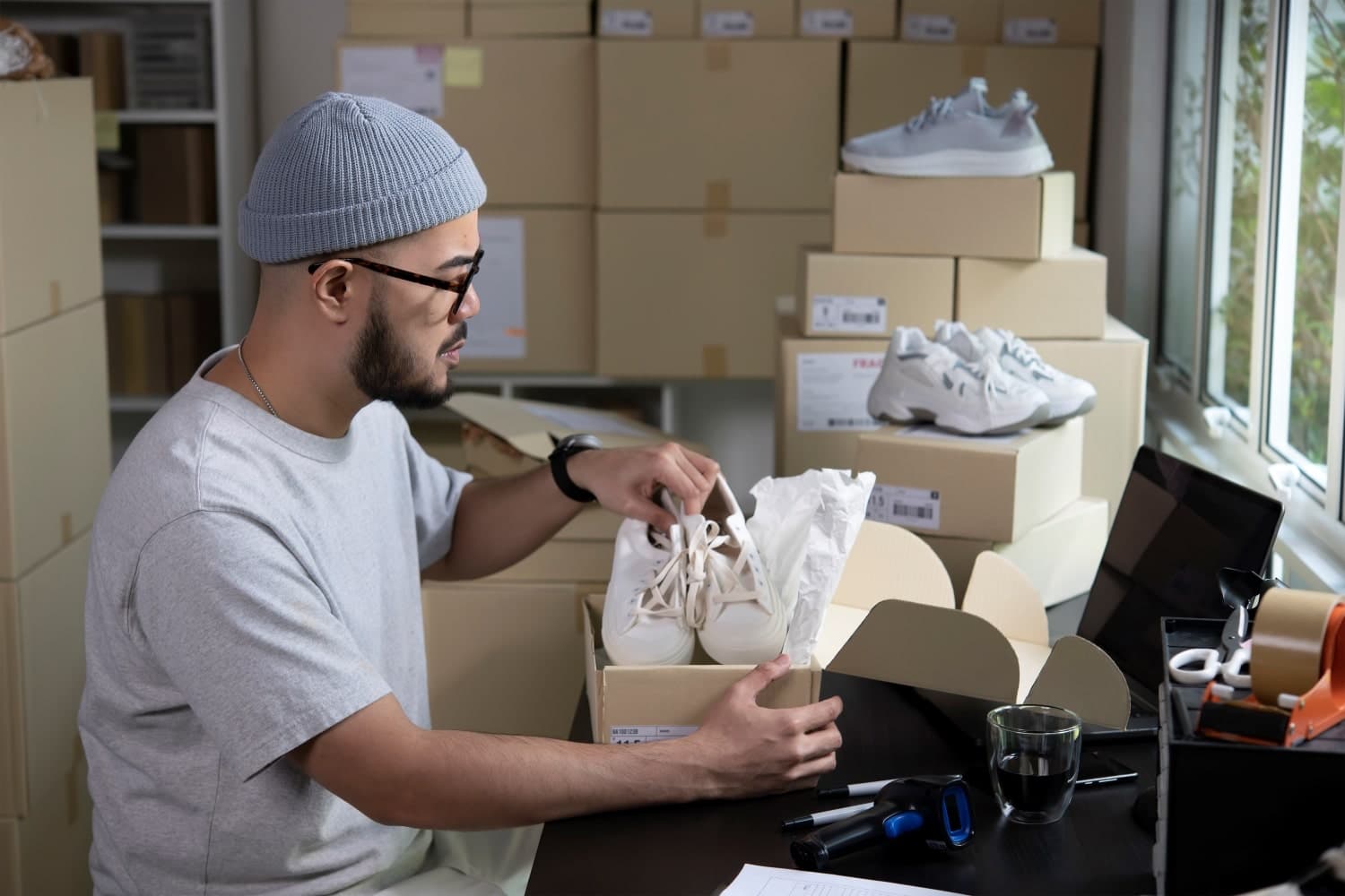 Fulfilment worker packing trainers into a box for dispatch